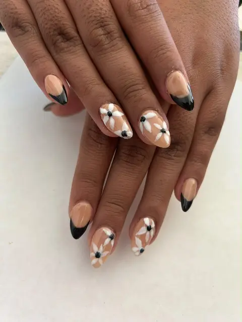 Uñas almendra con francés negro y flores blancas